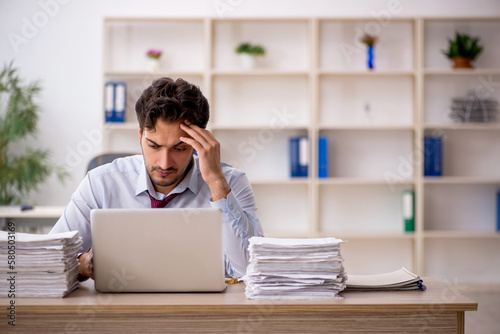 Young male employee and too much work in the office