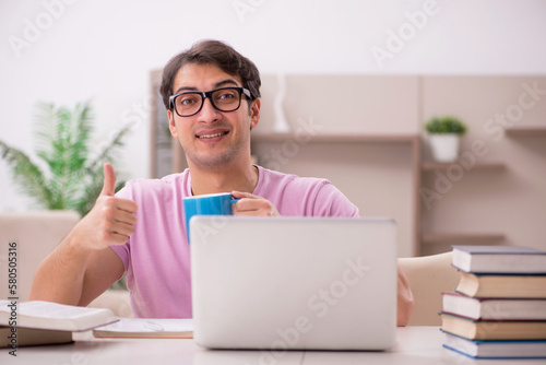 Young male student preparing for exams at home photo