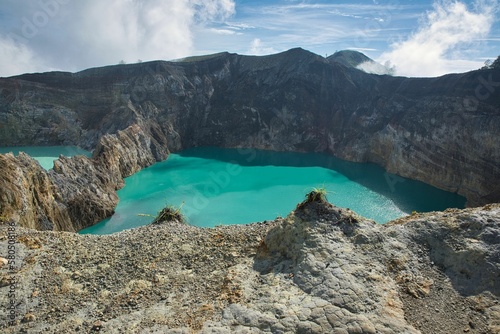 Panoramic view over the volcano Mount Kelimutu in Ende on Flores with its two sunlit turquoise crater lakes. photo