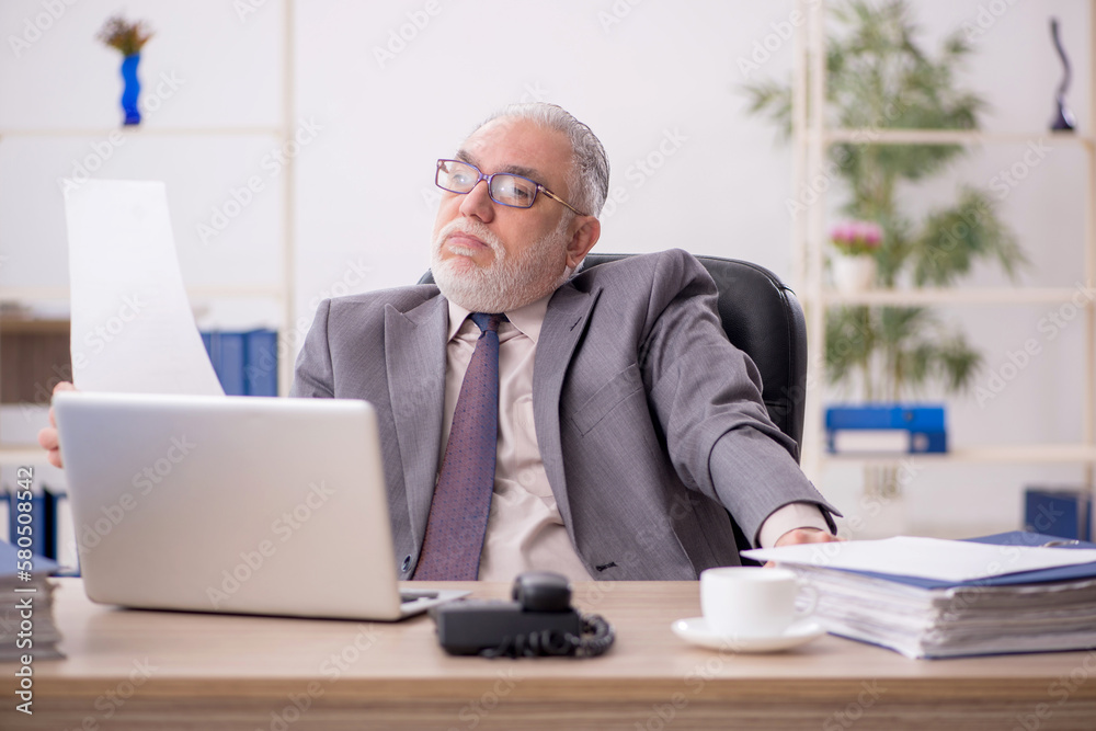 Old male employee working in the office Old male employee working in the office
