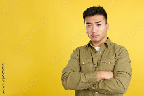 Serious chinese man with crossed arms and looking at camera