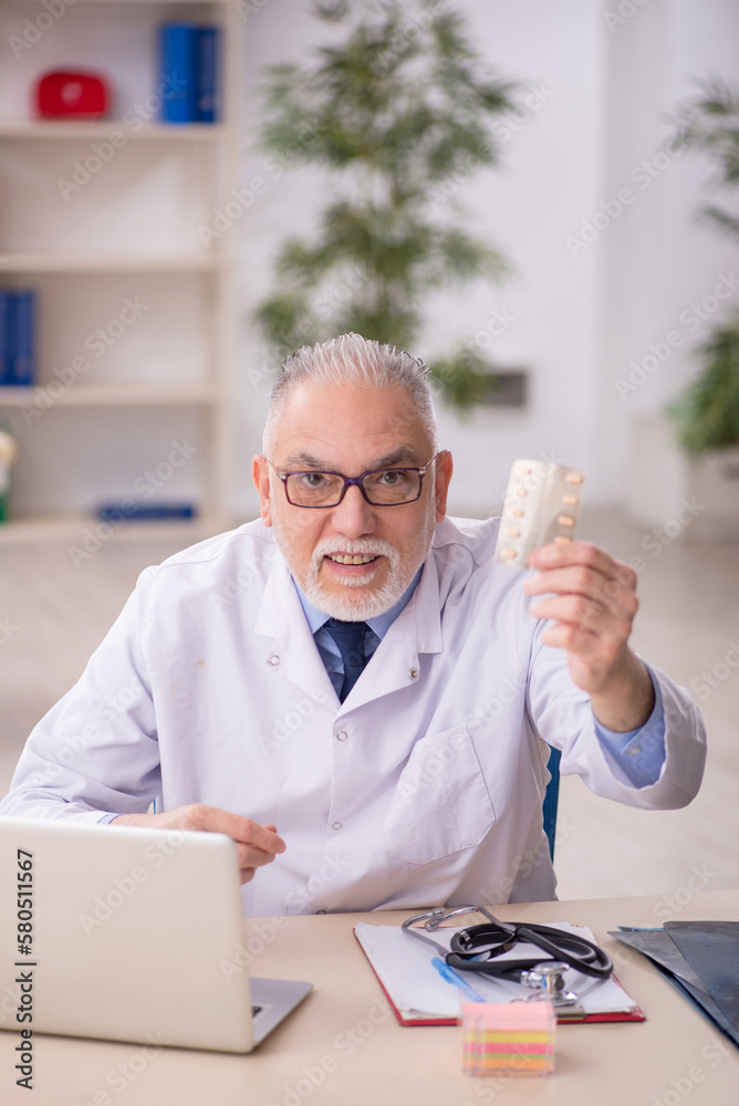 Old male doctor working in the clinic Old male doctor working in the clinic