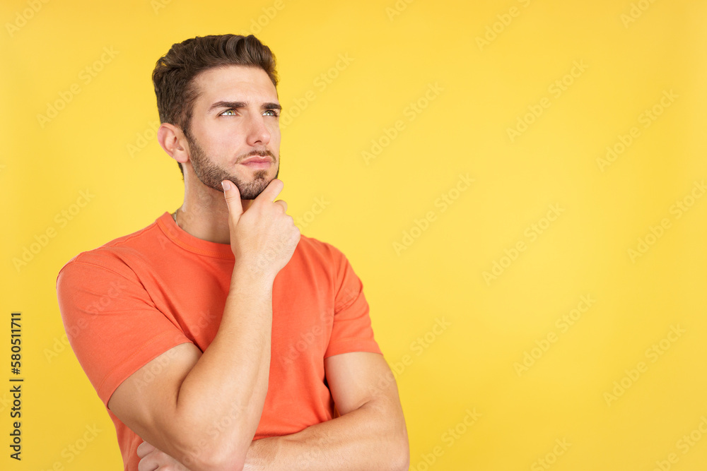 Caucasian man with hand on face and thoughtful expression Caucasian man with hand on face and thoughtful expression