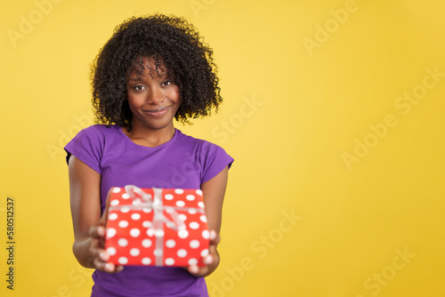 Generous woman with afro hair giving a present © Iván Moreno