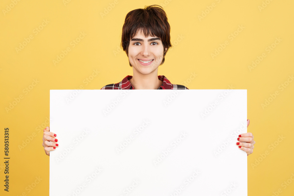 Androgynous person holding a blank panel while smiling Androgynous person holding a blank panel while smiling