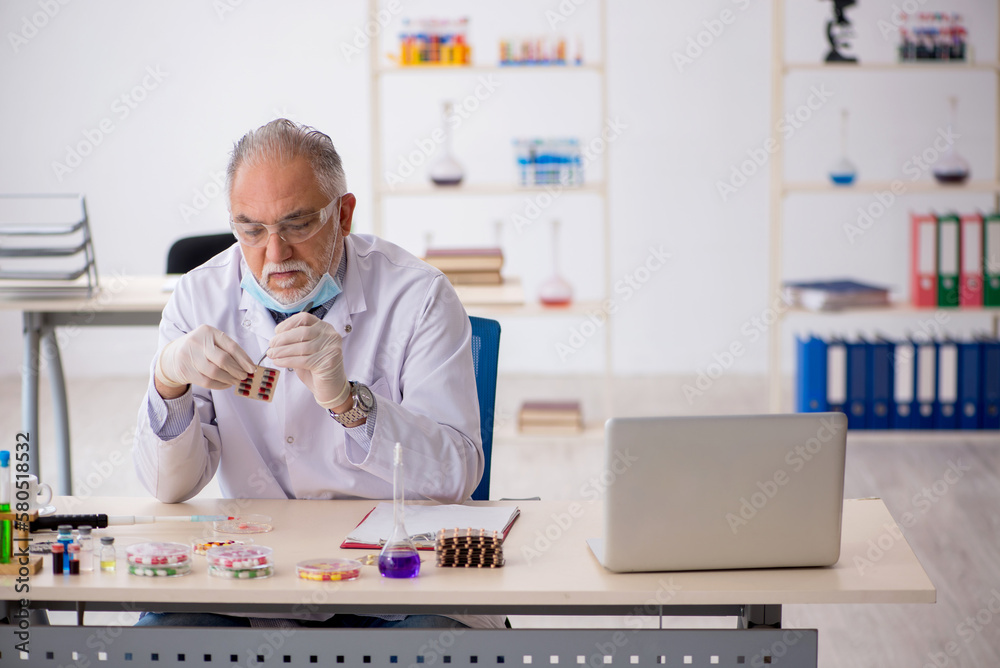 Old male chemist in drug synthesis concept Old male chemist in drug synthesis concept