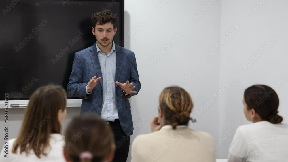 Experienced male teacher giving lecture to group of student ...