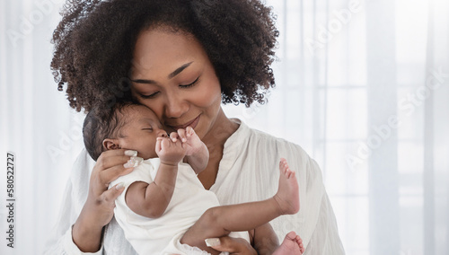 Close up portrait of beautiful young African American  mother holding sleep newborn baby in hospital bed room. Healthcare medical love black afro woman lifestyle mother's day, breast with copy space.