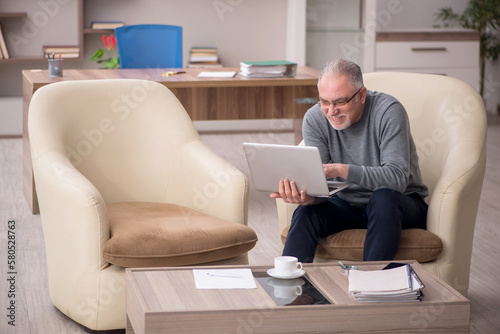 Old male employee working from home during pandemic