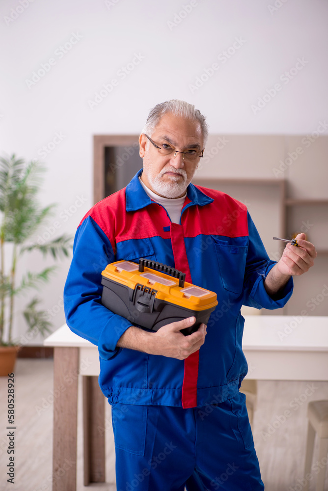 Old male carpenter working indoors Old male carpenter working indoors