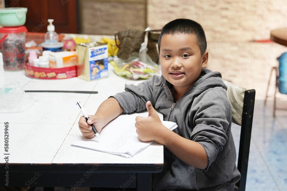 boy sitting holding pen and paper