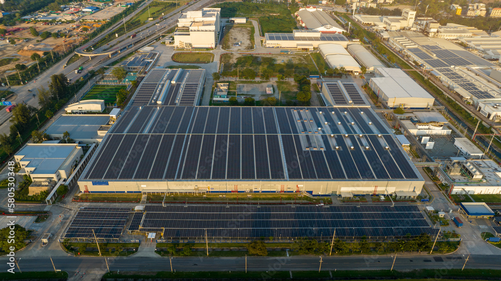 Top view Solar Panels on Warehouse Factory. Solar photo voltaic panels system power or Solar Cell on industrial building roof for producing green ecological electricity. Production of renewable energy