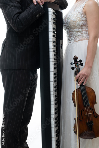 Violinist woman and pianist man playing together. Isolated neutral copy space. Studio portrait.