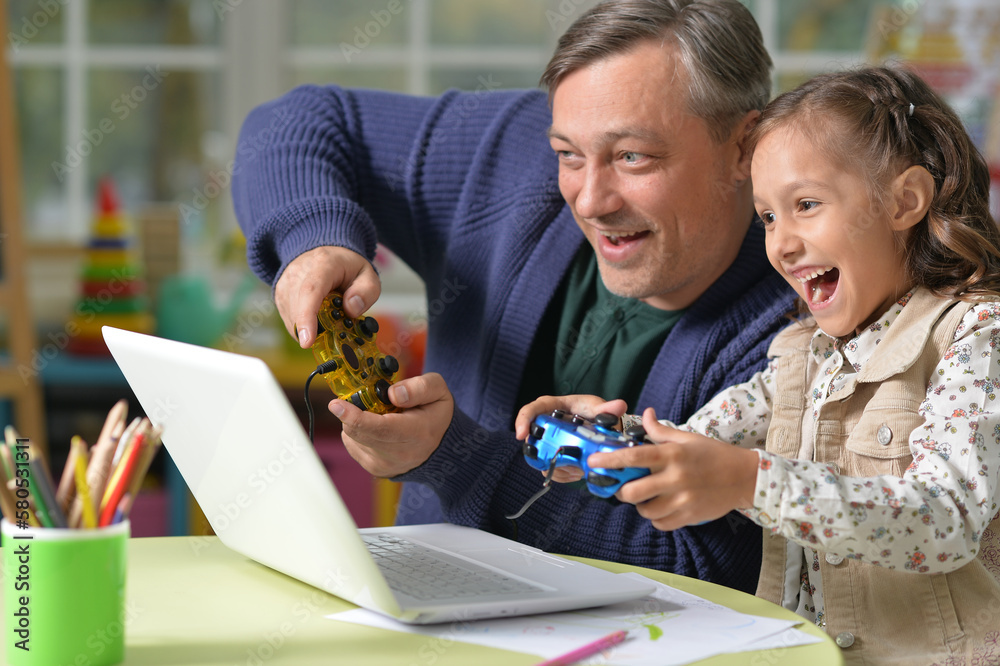 dad and kid have fun playing with a laptop 