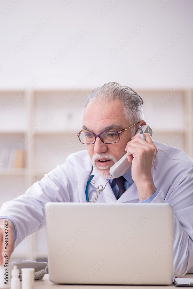 Old male doctor in telemedicine concept Old male doctor in telemedicine concept