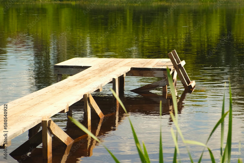 Fototapeta premium Old small Wooden Pier. No People. Beautiful Empty wood dock on River. Solitude, Loneliness concept. Reflections in water. Idyllic rural scene. Pastoral landscape. Ecological resort, fishing, swimming