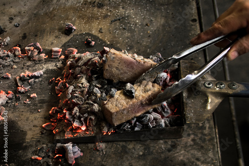 Cropped hand roasting meat on coal photo