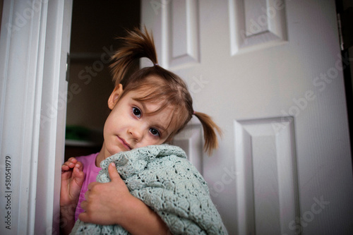 Portrait of girl holding shawl while standing at doorway photo