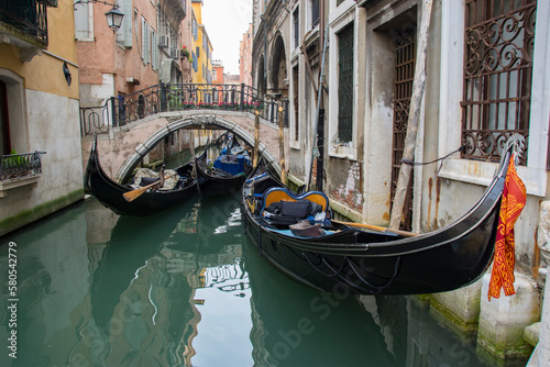 Gondolas in narrow canal by buildings photo