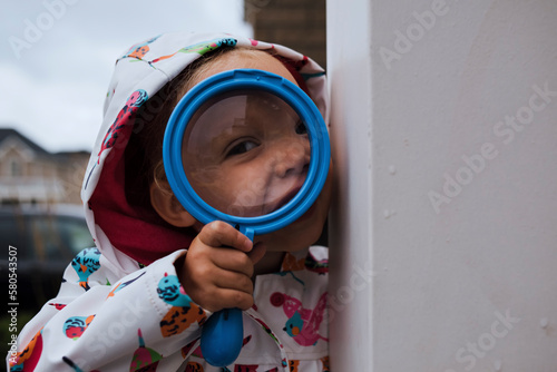 Portrait of girl holding magnifying glass photo