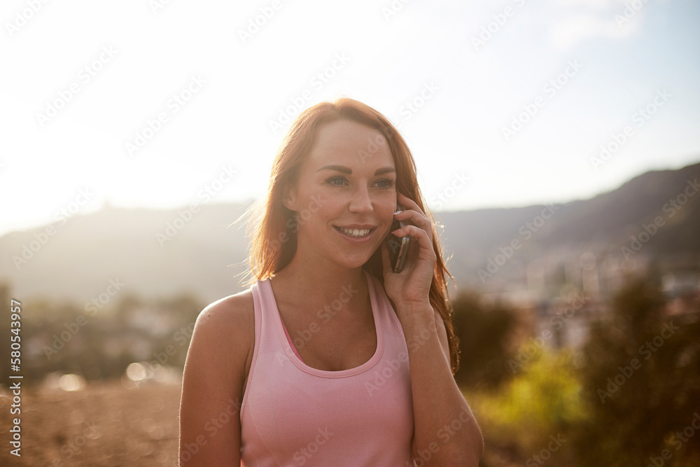 Happy woman talking on smart phone while standing against clear sky Happy woman talking on smart phone while standing against clear sky