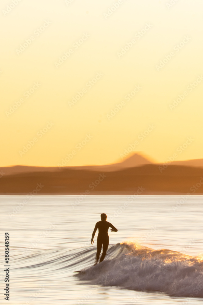 Surfer on sunset panning shot