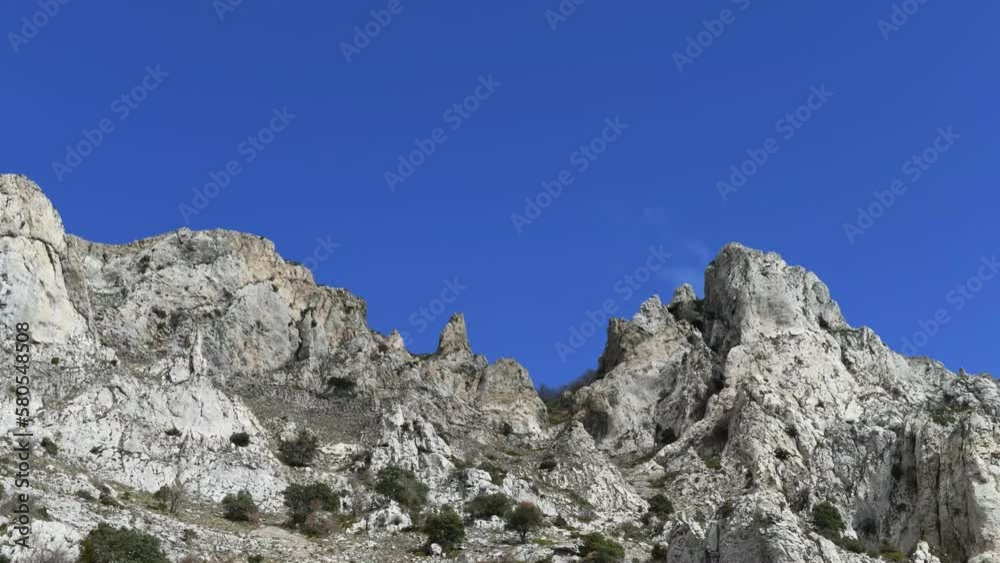 stone cross on a sky timelapse with a mountain in the shape of a peak, passing fast clouds, blue sky, space for text stone cross on a sky timelapse with a mountain in the shape of a peak, passing fast clouds, blue sky, space for text
