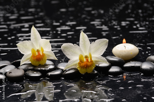 Spa still with white orchid, close up,candle with black zen stones,