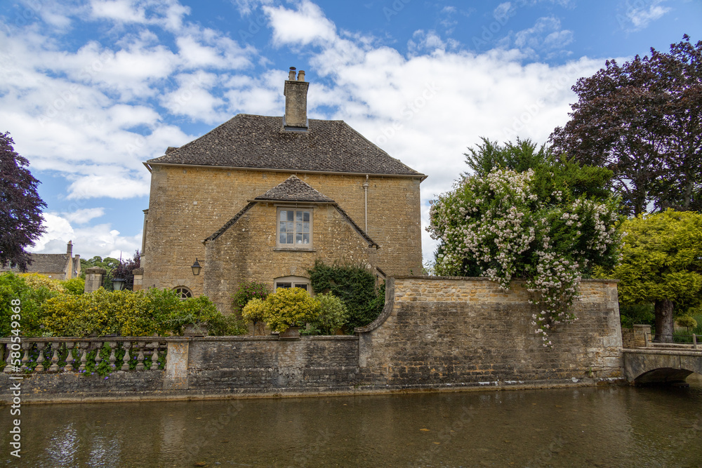 Burton on Water, UK, 28 june 2022. Wide angle views of the typical houses with shallow river in burton on the water small village in the Cotswold. Burton on Water, UK, 28 june 2022. Wide angle views of the typical houses with shallow river in burton on the water small village in the Cotswold.