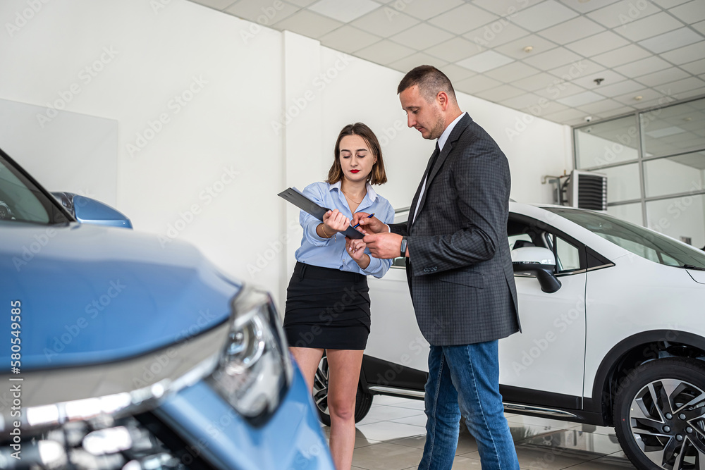 Female dealer in suit holding clipboard help with purchase new car her client Female dealer in suit holding clipboard help with purchase new car her client