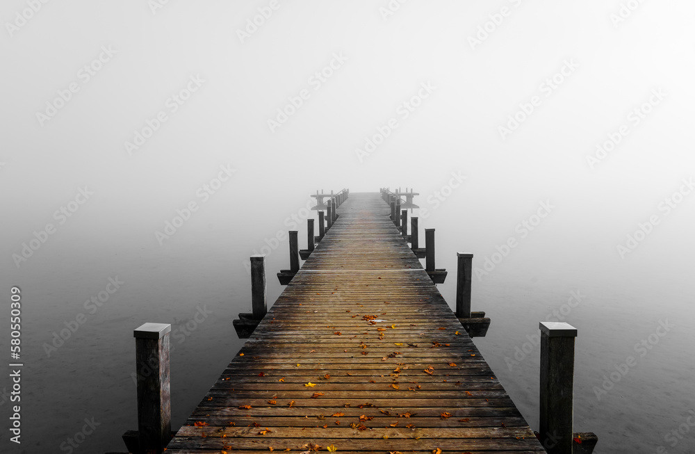 Obraz premium Jetty in the fog. Mystical foggy landscape at the lake. Morning fog in autumn. 