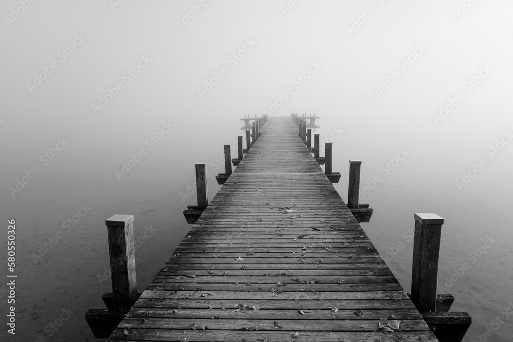 Jetty in the fog. Mystical foggy landscape at the lake. Morning fog in autumn. Jetty in the fog. Mystical foggy landscape at the lake. Morning fog in autumn.