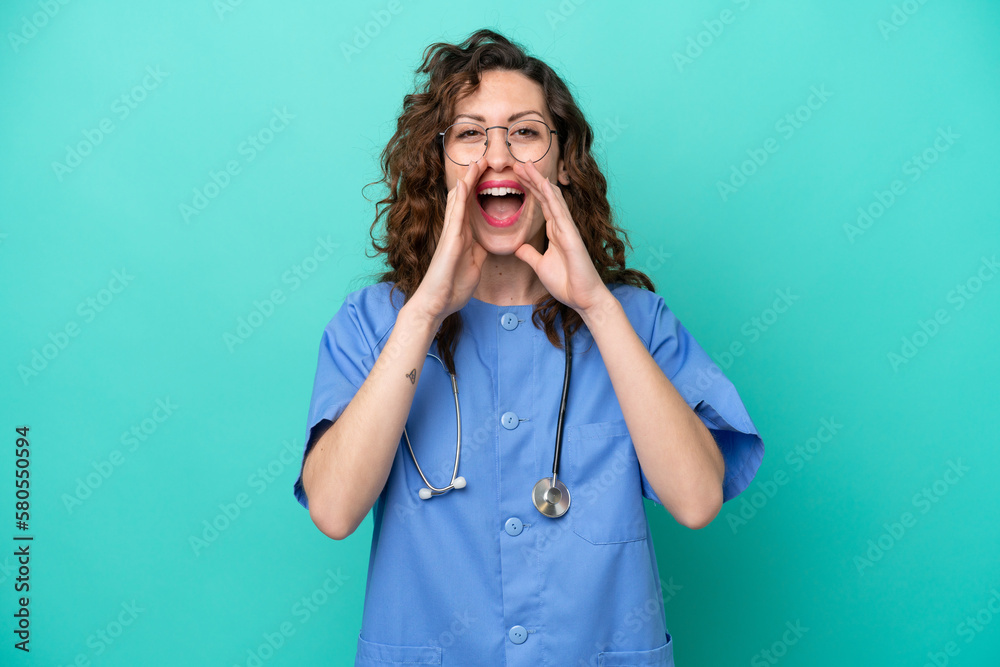 Young nurse caucasian woman isolated on blue background shouting and announcing something Young nurse caucasian woman isolated on blue background shouting and announcing something