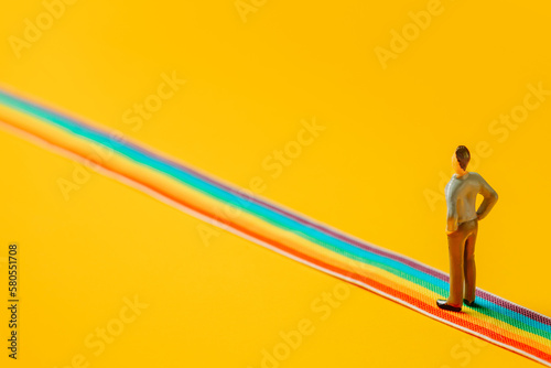 Adult man figure stand on rainbow LGBT strip