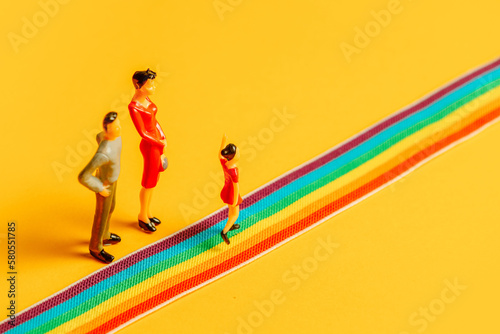 little parents and daughter figures on the LGBT rainbow path