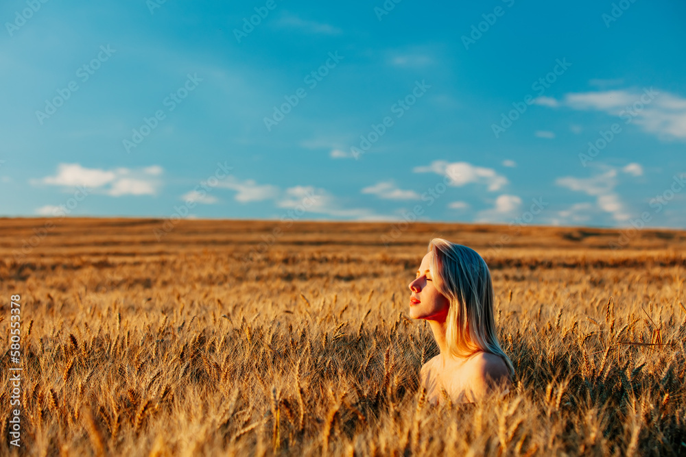 Blonde woman without clothes in wheat field in sunset time Blonde woman without clothes in wheat field in sunset time