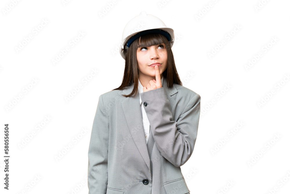 Little girl playing as a architect with helmet and holding blueprints over isolated background having doubts while looking up Little girl playing as a architect with helmet and holding blueprints over isolated background having doubts while looking up