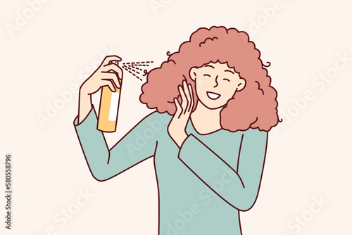 Woman uses spray to create cool hairstyle before going to party or gala dinner. Girl is engaged in independent hair care, wanting to have beautiful hairstyle thanks to cosmetic products 