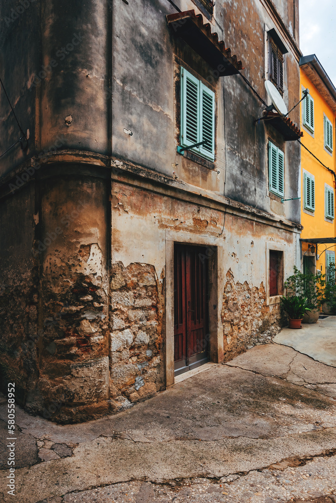 Old town of Lovran in Croatia, distinctive Istrian architecture with worn facades and wooden window shutters