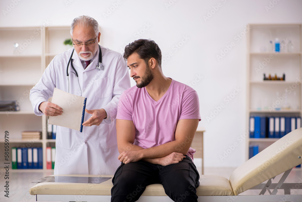 Obraz premium Young male patient visiting old male doctor
