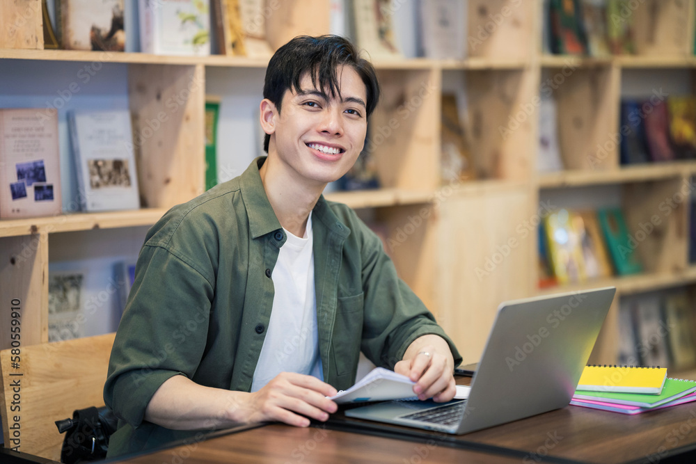 © Timeimage - Young Asian man studying at library