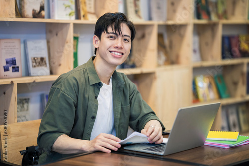 Young Asian man studying at library