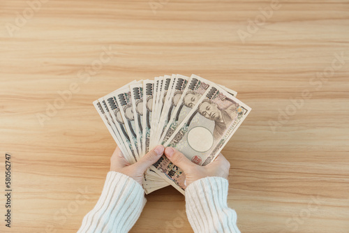 Canvastavla Woman hand counting Japanese Yen banknote over table background
