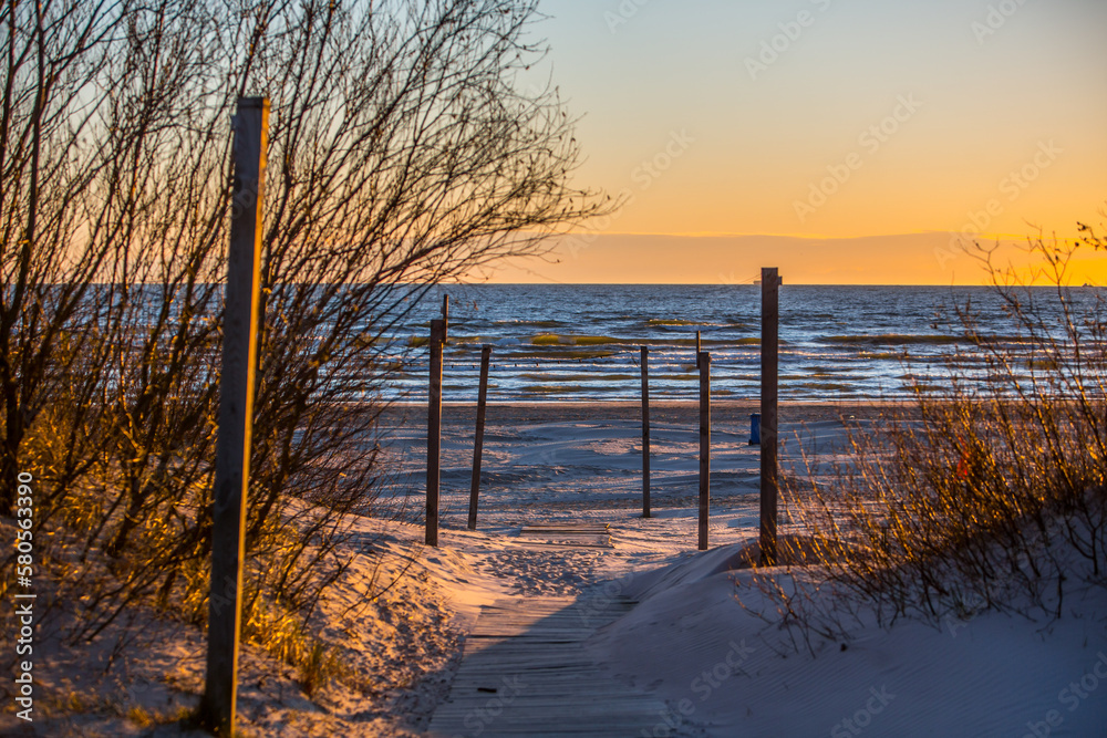 Scenic wooden pole walkway to beach in sunset