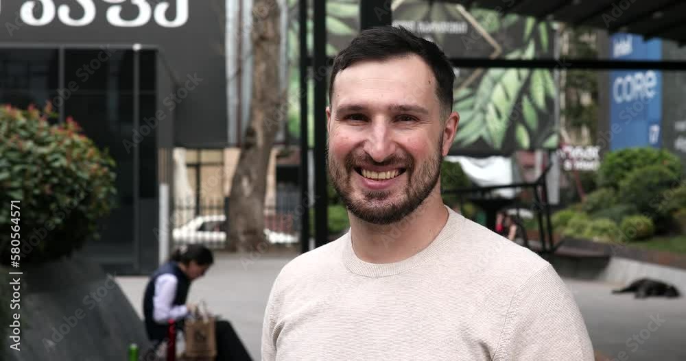 Portrait of attractive stylish young bearded man looking into the camera and smiling.
