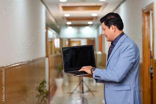 Indian businessman using laptop at office.