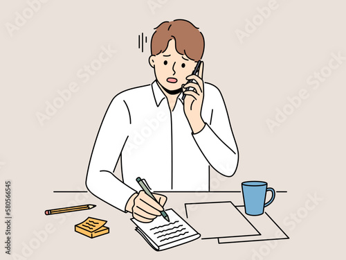 Unhappy man sit at desk talk on phone taking notes. Upset guy feel stressed with news on cellphone handwrite in notebook. Vector illustration. 