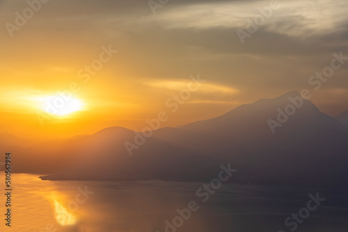Italy, Veneto, San Zeno di Montagna, Lake Garda at cloudy sunset with Monte Pizzocolo in background photo