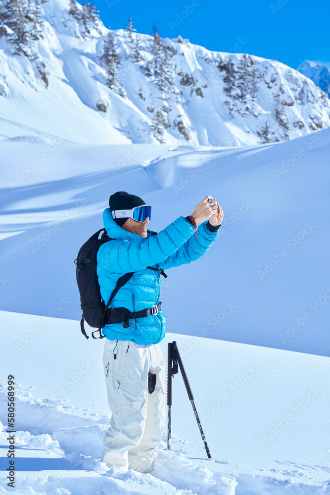 Mature man in snow photographing on sunny day Mature man in snow photographing on sunny day