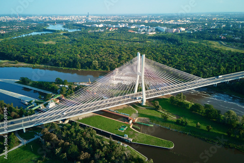 Aerial drone view of Redzinski bridge over Odra river in Wroclaw city, Poland. Large cable stayed bridge with car traffic in european city, bird eye view. Transportation infrastructure and logistic